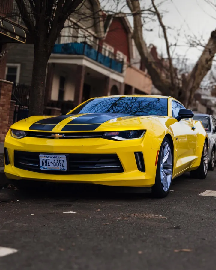 Yellow Chevrolet Camaro with black stripes on a Brooklyn street