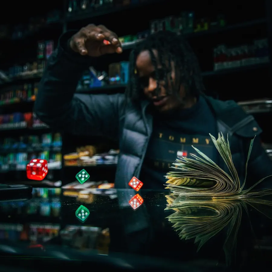 Man in a deli throwing playing cards and dice toward the camera