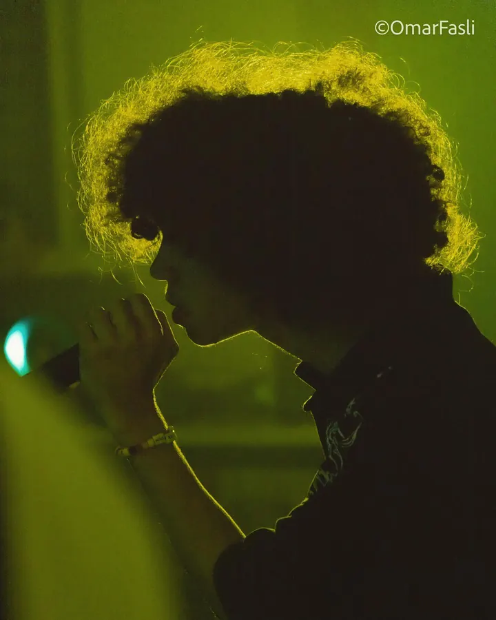 Performer in silhouette with green rim light