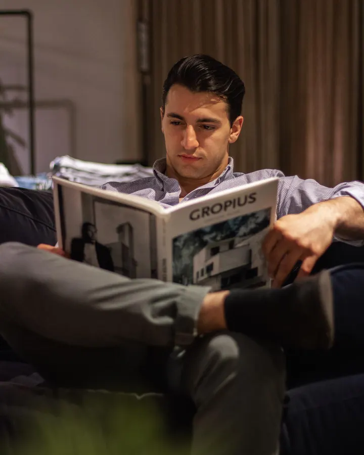 Man in an armchair reading a design magazine