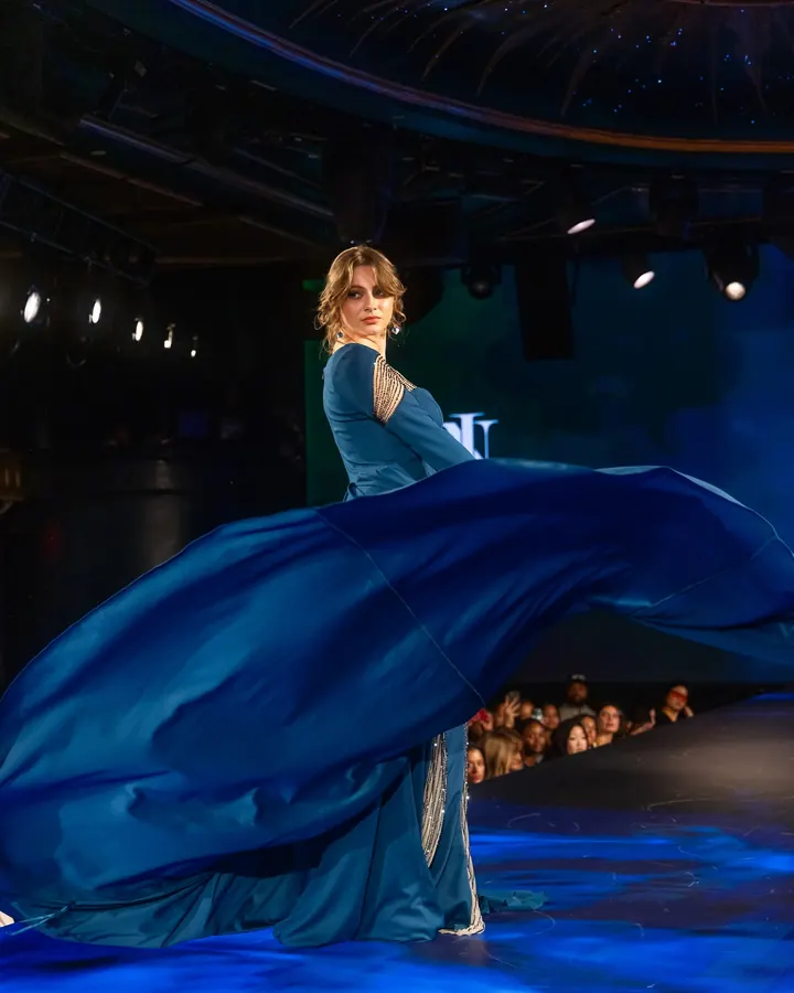 Model spinning a blue gown on the runway at New York Fashion Week