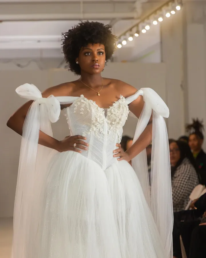 Model in a white bridal gown with bow sleeves on the runway