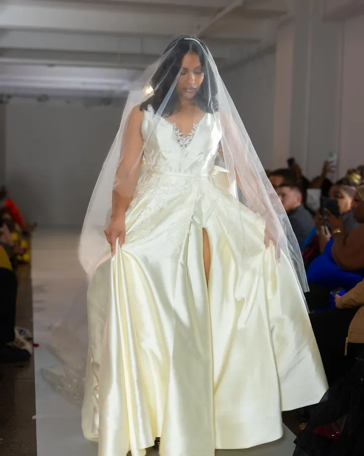 Model in an ivory gown and veil on the runway