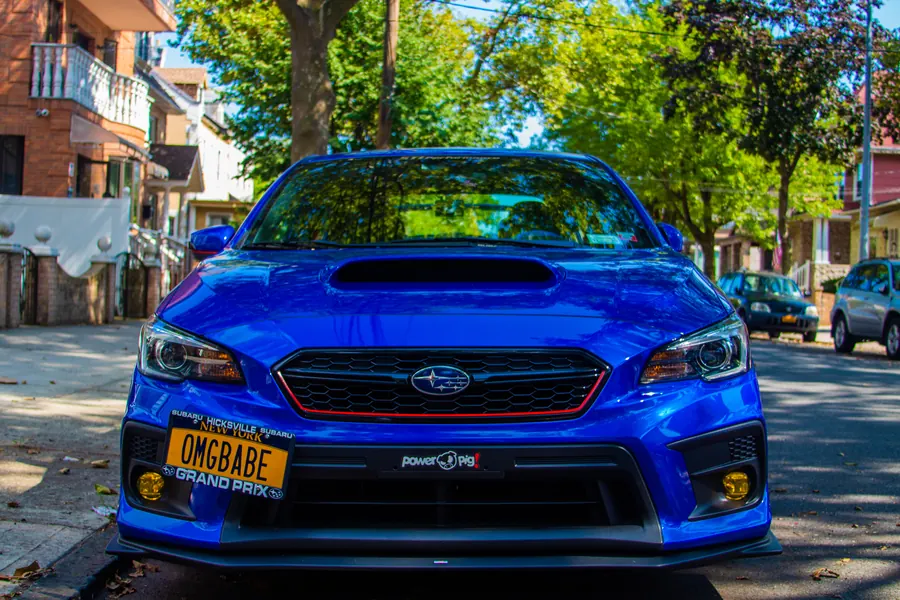 Blue Subaru WRX STI parked on a Brooklyn street, head-on