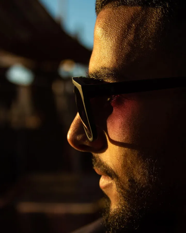 Profile of a bearded man in sunglasses at sunset